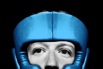 Black-and-white close-up photo of Mark Zuckerberg wearing blue sparring headgear