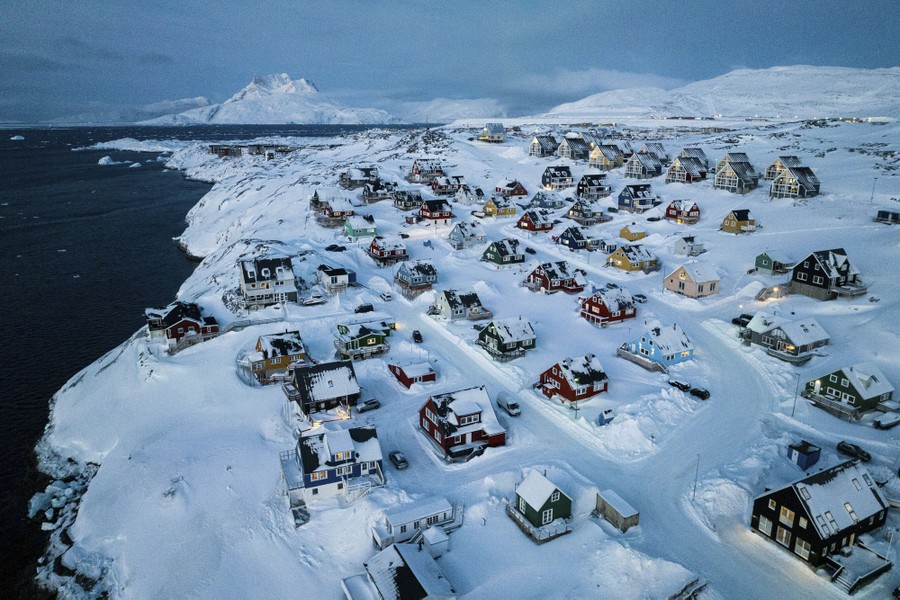 An elevated view of a neighborhood on a snow-covered coastal hillside.