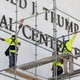 Workers on scaffolding are seen near the sign outside the John F. Kennedy Center. Trump's name is still up.