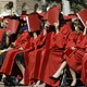 Women in graduation gowns covering their faces