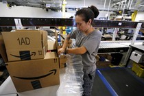 Monica Galvan secures customers' orders with air cushions at the Amazon Fulfillment Center in Tracy, California.