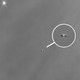 A black-and-white view of a planetary system in the making from afar, captured by the James Webb Space Telescope