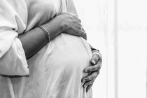 A pregnant woman holds her belly.