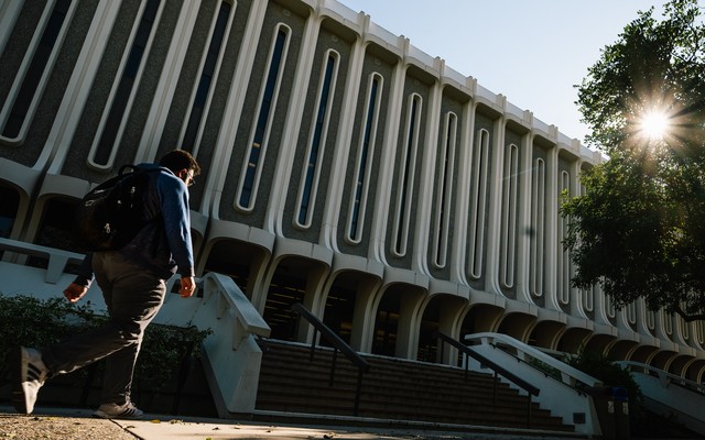 A man walks past Langson Library, at UC Irvine.