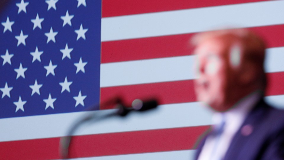 Donald Trump in front of an American flag.