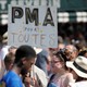 A participant in the Paris gay pride parade holds up a placard which reads "PMA (Fertility treatment) for all."