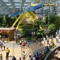 A photo showing visitors to the Mall of America, people in line to buy tickets, and a yellow-and-blue ride in the background