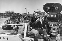 John Wayne dressed as a cowboy directs the filming of "The Alamo" in 1960.
