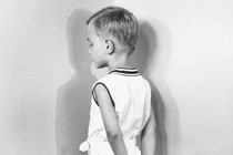 Boy in corner facing a wall