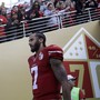 Colin Kaepernick walks out of a tunnel before an NFL football game.