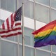 An American flag and a rainbow pride flag are pictured next to each other. 