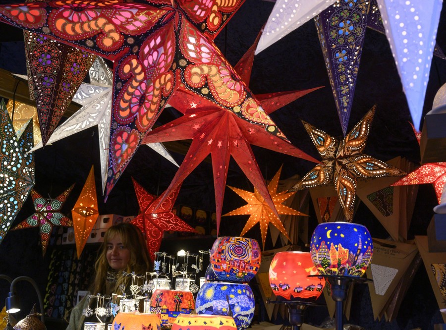 Illuminated paper stars are displayed in a booth.