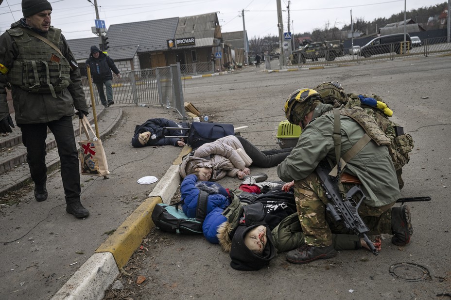  Ukrainian soldiers attend to a group of civilians, including Tetiana Perebyinis and her two children, who were mortally wounded by a Russian mortar round while they evacuated on March 6, 2022 from Irpin, Ukraine