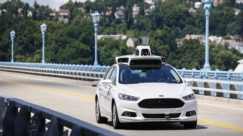 Uber employees test a self-driving Ford Fusion in Pittsburgh, in August 2016. 