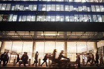 People pass a building at night