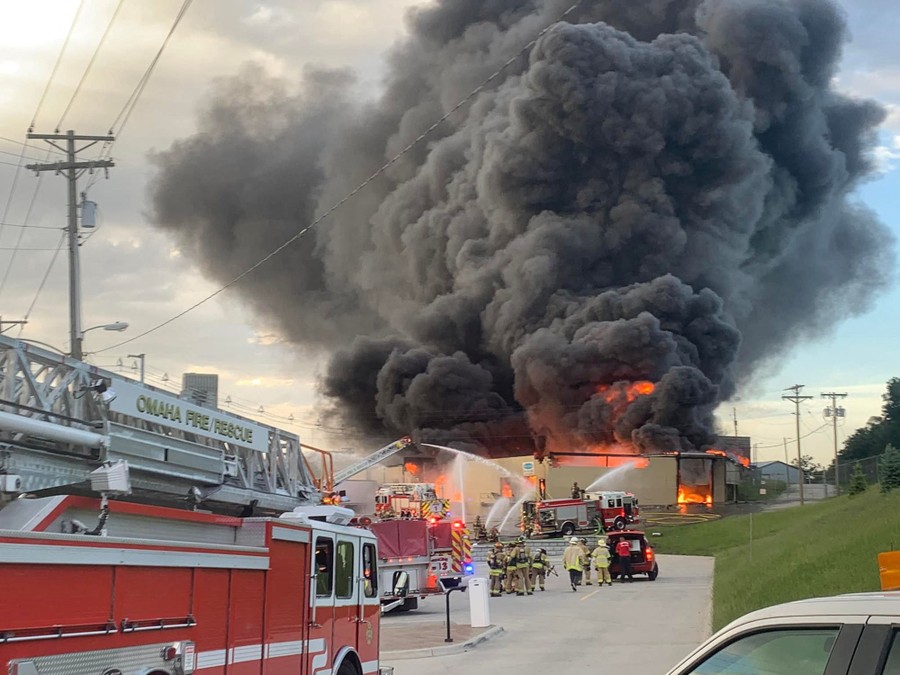 Firefighters work to extinguish a fire as smoke billows at a chemical plant.