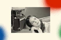 A black-and-white photo shows a high-school-aged girl reclining on her 1950s-era couch with her ear next to an old radio on a side table. Her hands are folded under her chin and she's gazing off to the right as she listens. The photo is set against a background with three spray-painted colorful circles. In the bottom left corner is a blue one, in the bottom right corner a green one and the top right corner is a red one.