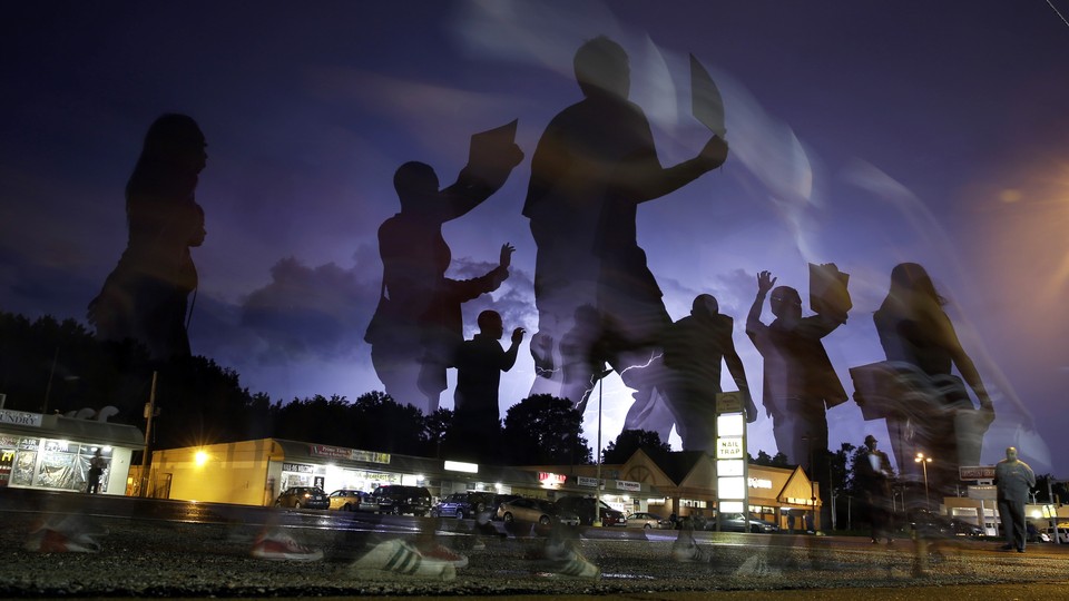 A silhouette of protestors superimposed over a strip mall