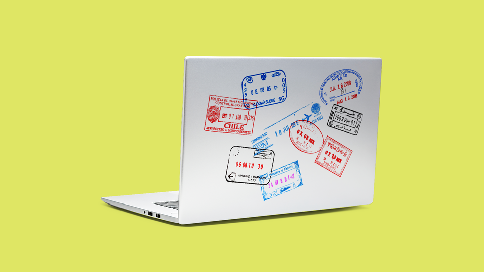 A laptop with passport stamps on the front