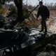 A Ukrainian fighter steps onto a tank.