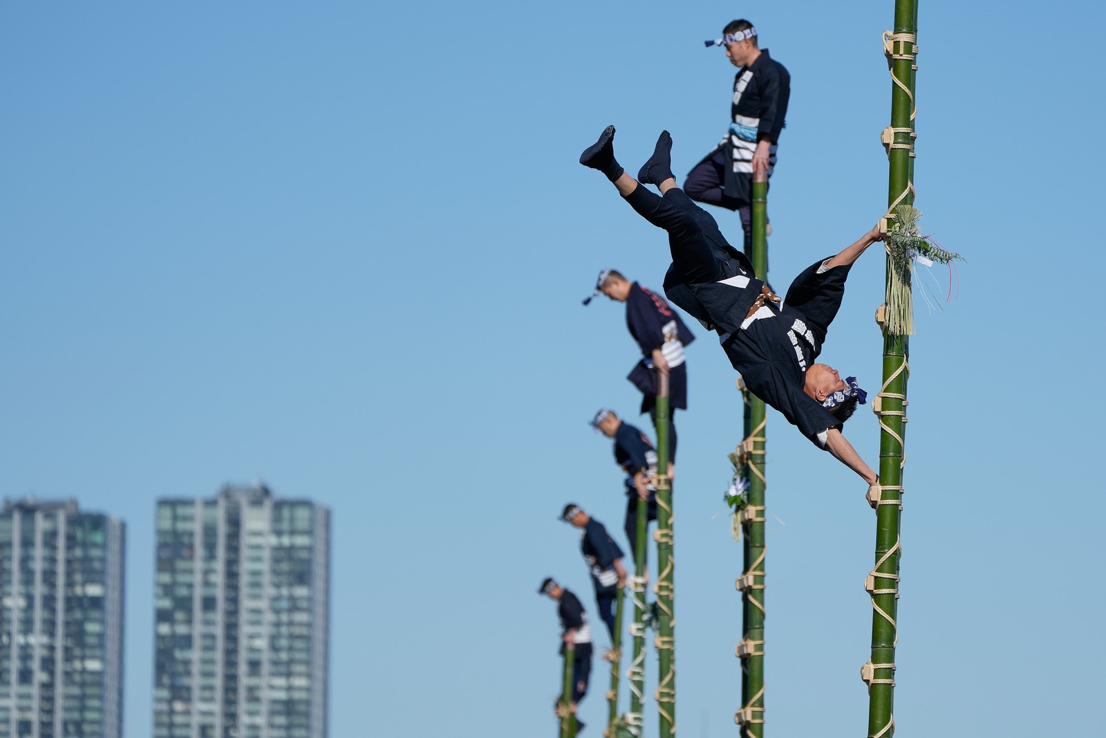 Members of a traditional firefighting preservation group perform atop tall bamboo ladders.