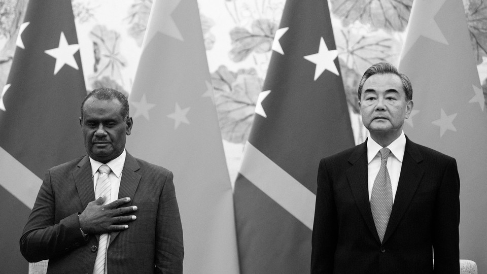 China's Foreign Minister Wang Yi stands alongside Solomon Islands' Foreign Minister Jeremiah Manele