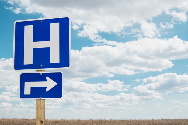 Hospital road sign in an open field.
