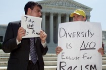 Two male students protest outside of the Supreme Court with signs accusing affirmative action of being racist.