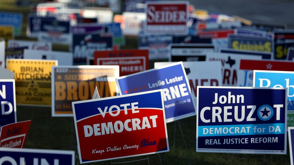 Dozens of colorful campaign signs are posted in the grass outside of a polling station on the last day of early voting in Dallas, Texas, before the 2018 midterm election.