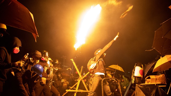 Anti-government protesters throw Molotov cocktails during clashes with police outside Hong Kong Polytechnic University.