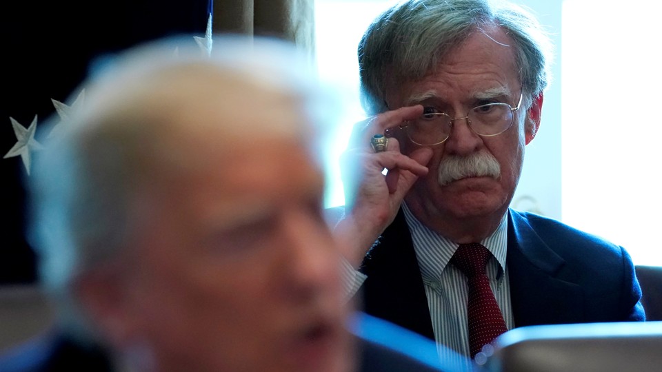 John Bolton stares at Donald Trump during a Cabinet meeting.