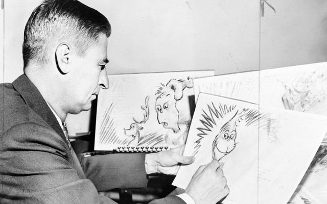 Theodor Seuss Geisel, American writer, poet, and cartoonist, at work on a drawing of a grinch.