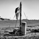 USA. Stratford, California. 2013. A man repairs his dry well.