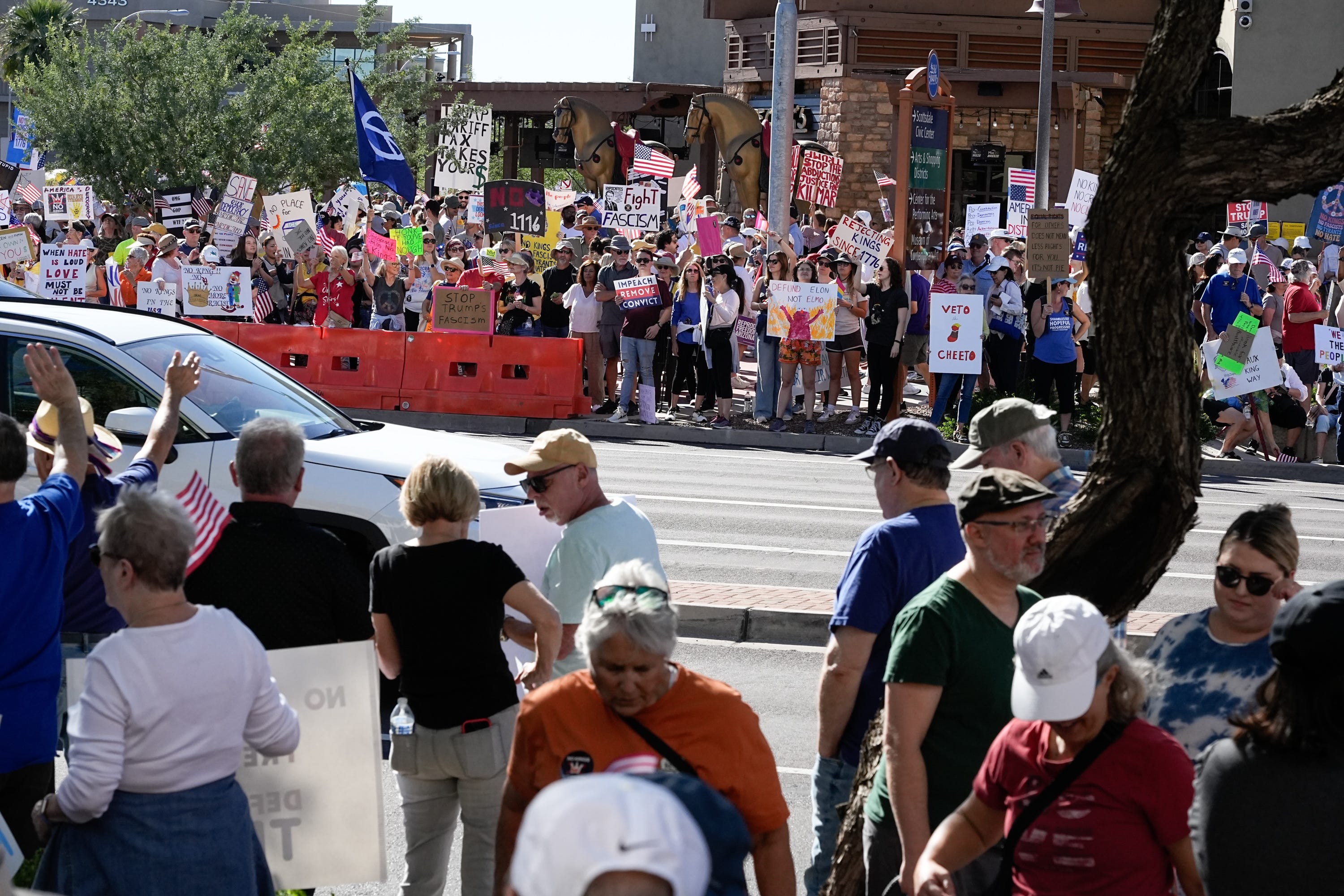 Demonstrators holding signs stand on either side of a road.