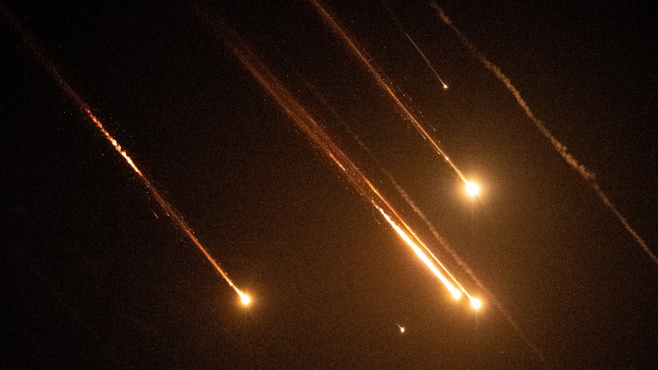 A color photo of missiles streaking across a night sky