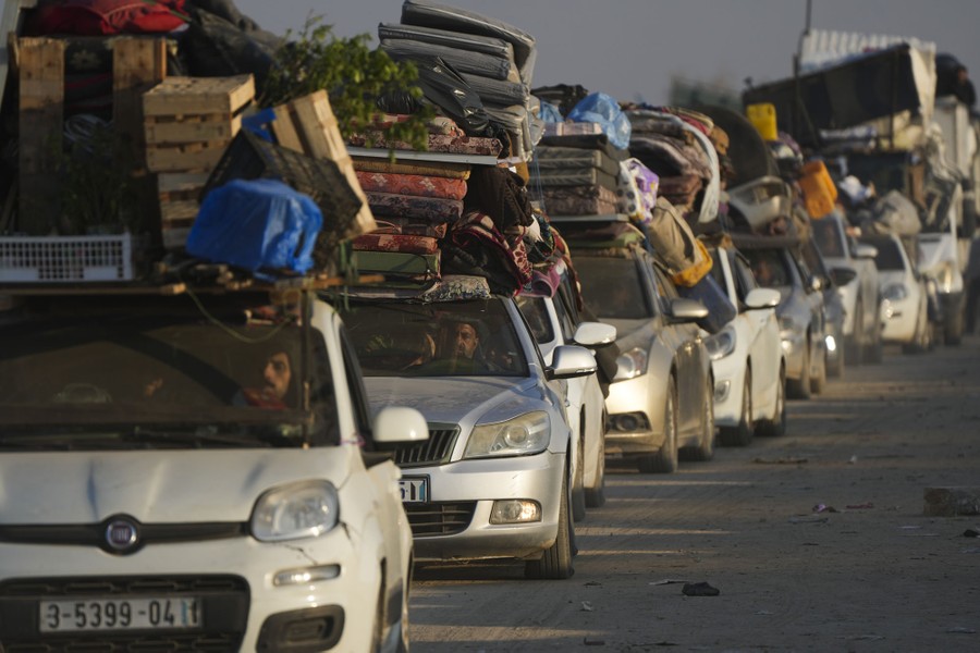 A long line of passenger cars, each stacked high with boxes and mattresses and other household items.