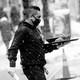 A restaurant server holds a tray while walking outside in the snow.
