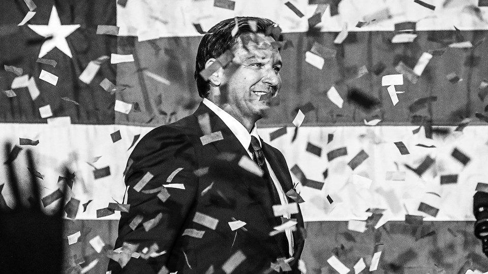 A black-and-white photo of Ron DeSantis amid falling confetti