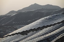 An aerial view of solar panels covering several hillsides.