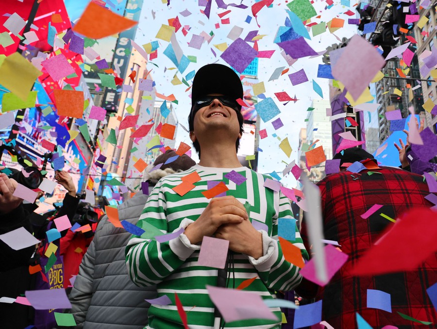 People stand in Times Square during a daytime confetti test.