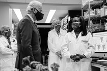 President Joe Biden listens to Kizzmekia Corbett, an immunologist with the Vaccine Research Center at the National Institutes of Health. Antony Fauci stands in the background.