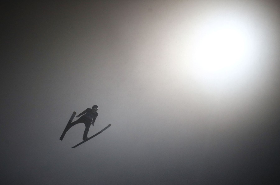 A ski jumper, seen in mid-flight