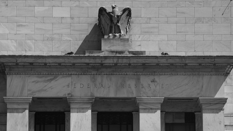 A black-and-white photograph of the facade of the Federal Reserve building