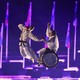 Two dancers, one in a wheelchair, are suspended above a stage during a performance at the Paralympic Opening Ceremony.