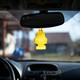 Two yellow air fresheners hang from a car mirror