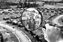 A suburb, with two-parent and 3-kid family visible through magnifying glass