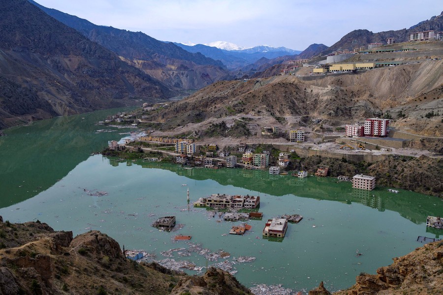 A view of flooding filling a valley, submerging buildings