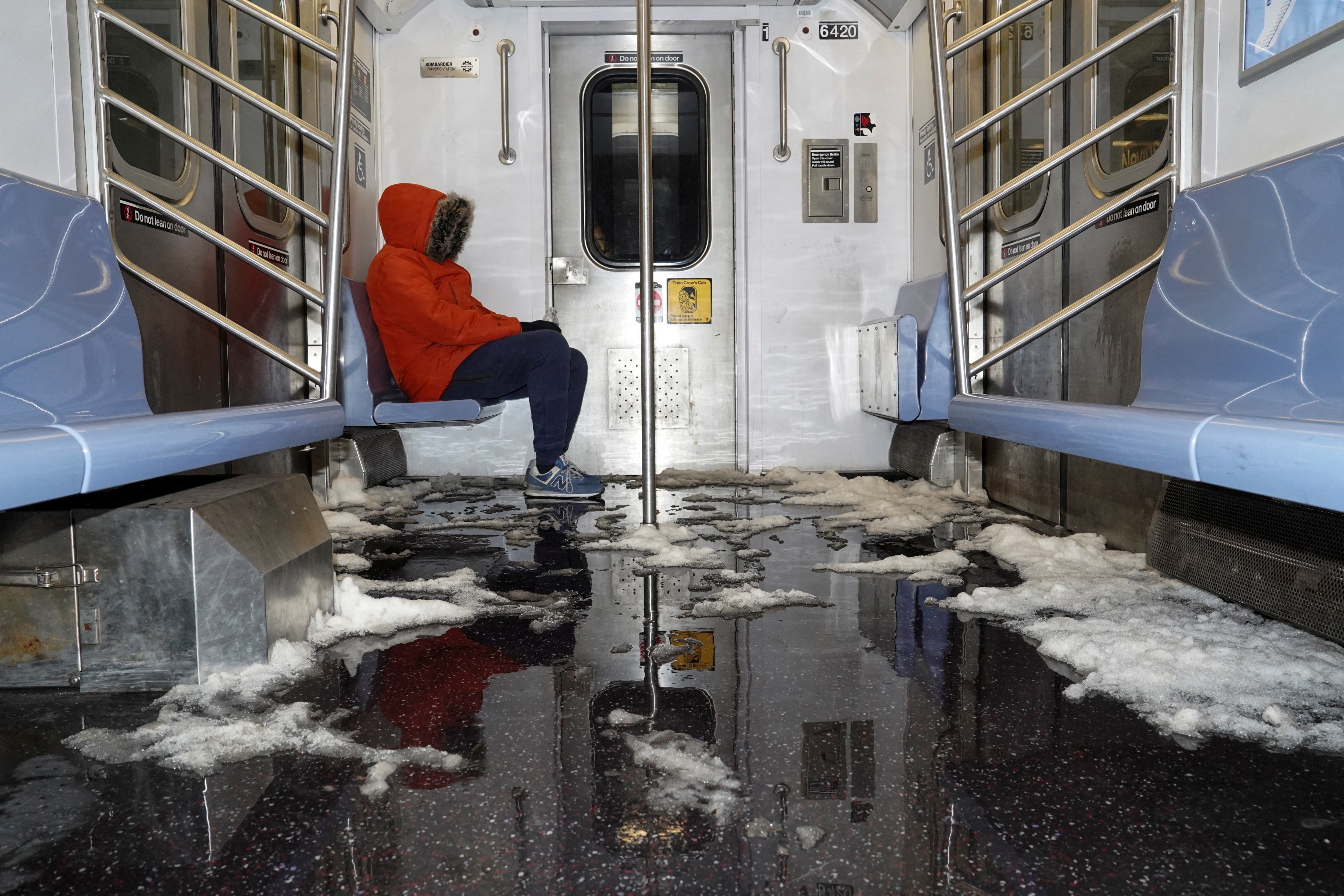 Snow and ice cover the floor of a subway car.