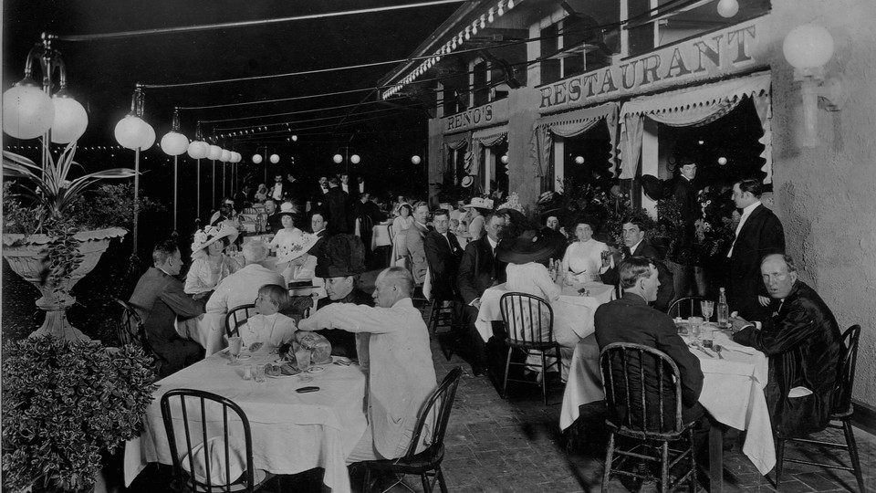 A black-and-white photo of people dining outside