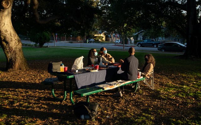 A family eating holiday dinner outside.